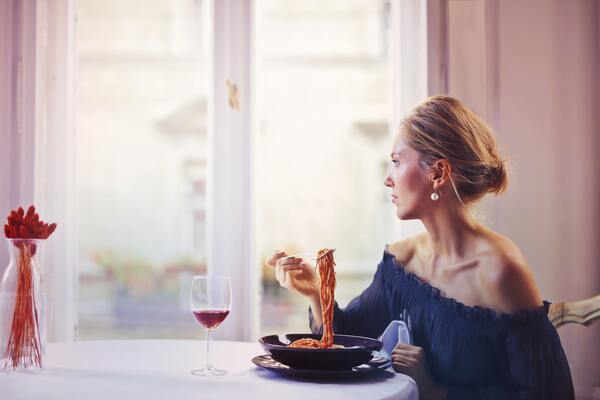 Femme devant une assiette de spaghetti